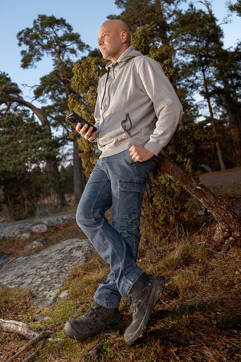 Touko Koskinen ulkona kallion ja metsän keskellä